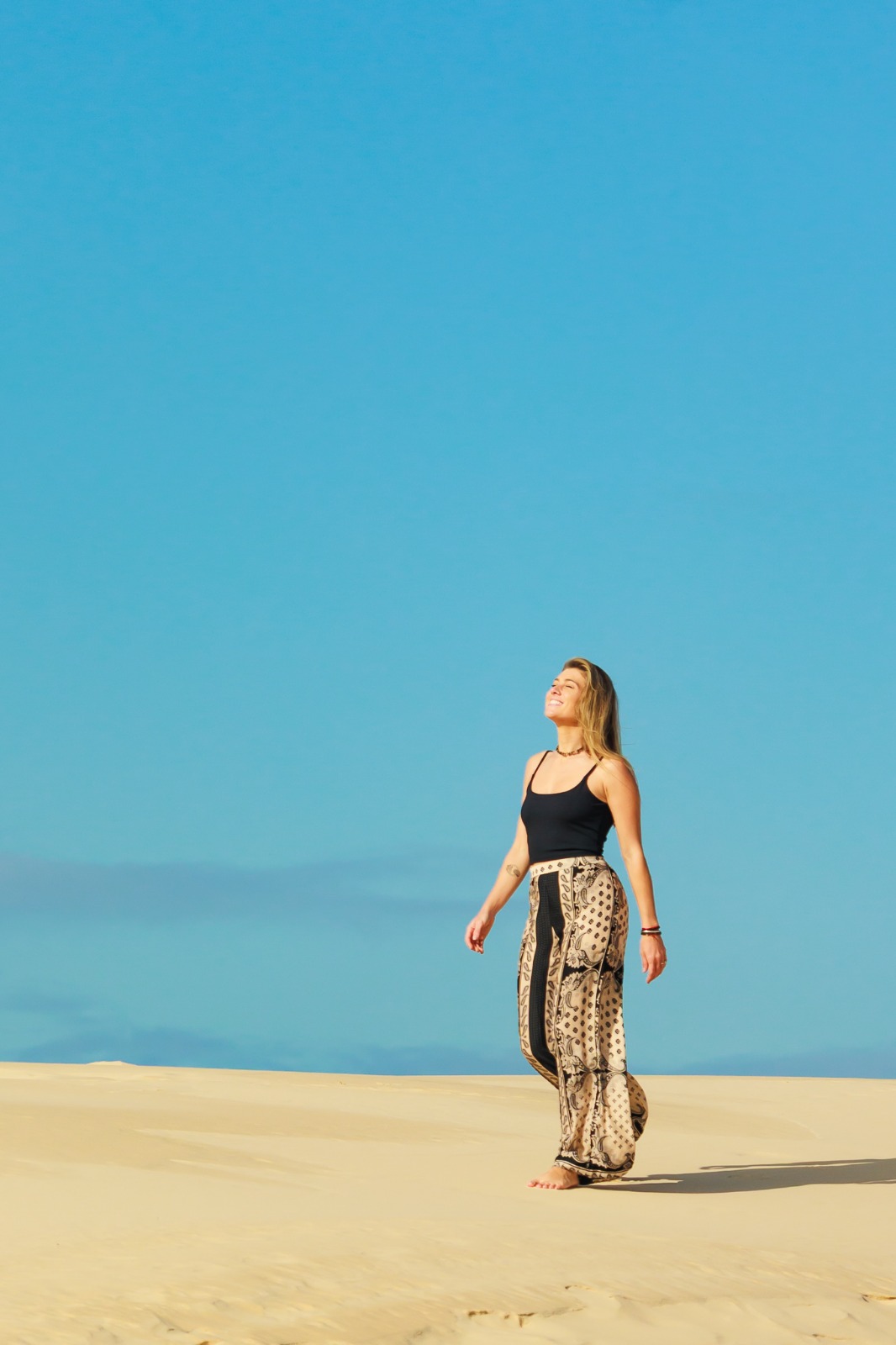 Mariana Schneider caminhando nas dunas